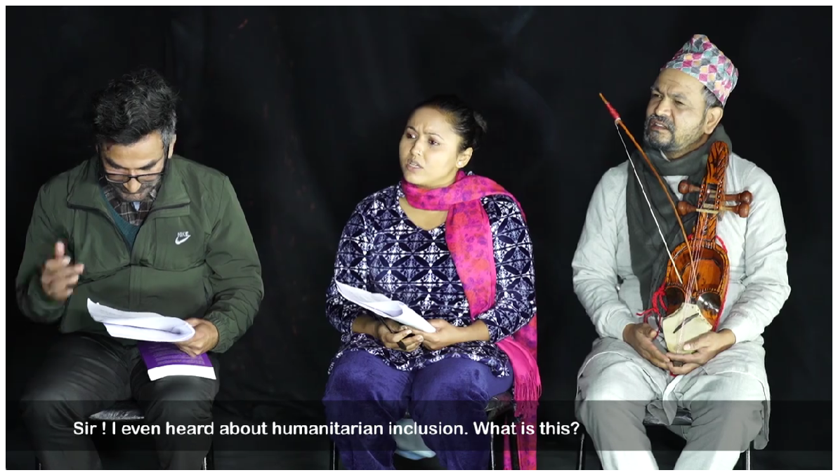 An image from a Sphere theatre performance. The man on the left has a Sphere Handbook and a script. The man on the right holds a stringed musical instrument. The woman at the centre of the image is talking. The caption is: Sir! I even heard about humanitarian inclusion. What is this?